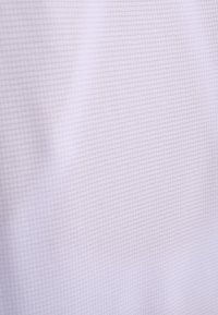 Levanduľová látka s jemným mriežkovým vzorom a mäkkými záhybmi vytvára jemné tiene a textúru.