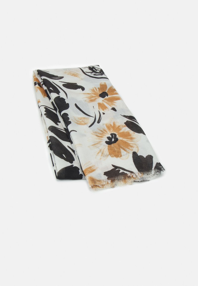 Tela blanca doblada con patrones florales en negro y marrón claro y bordes deshilachados sobre un fondo claro liso.