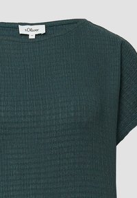 Groene textuur top met een ronde halslijn en korte mouwen. Heeft een lichte stretch en subtiele horizontale ribbels. Merkenlabel zichtbaar.