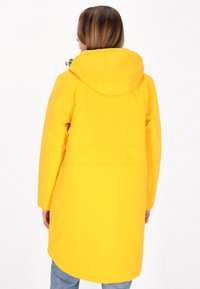 Gelbe wasserdichte Jacke mit Kapuze, langen Ärmeln, mittellanger Passform und glatter Textur. Verfügt über einen Kordelzug am Hals und Seitentaschen.