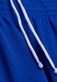 Blauwe sportshorts van ademend materiaal met kleine perforaties, met een witte trekkoord en een elastische tailleband.