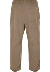 Brune bomullsbukser med elastisk midjebånd, tapered ben og baklomme. Glatt tekstur med en avslappet passform.