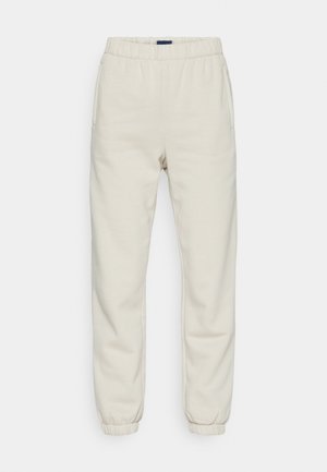 Cream-colored sweatpants made from soft material, featuring an elastic waistband, side pockets, and cuffs at the ankles.