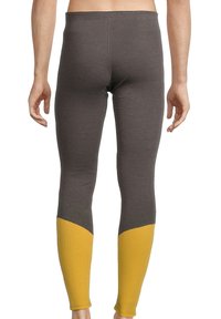 Grijze legging met een aansluitend ontwerp, voorzien van een gestructureerde gele accent op de onderbenen en een gladde afwerking overal.