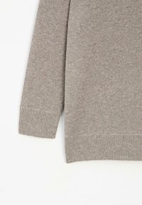 Grijze gebreide trui, met een zachte textuur, geribbelde manchetten en zoom, en een relaxte pasvorm met een subtiel patroon overal.