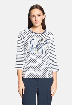 Top à manches 3/4 rayé blanc et marine avec un patch à motif géométrique ; encolure ronde, tissu doux, coupe décontractée.