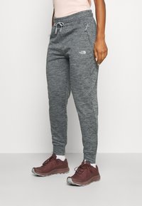 Grå sweatpants med en strukturerad tyg, elastisk midja och dragsko. Har två sidofickor och en liten logga på vänster lår.