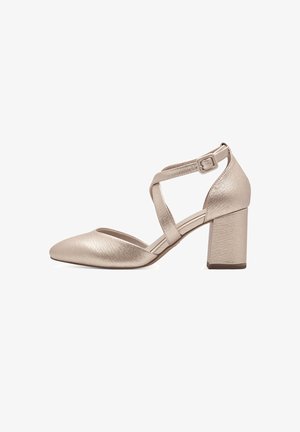 Metallic beige block-heeled shoe with a pointed toe, cross-strap design, and textured surface. Adjustable ankle strap for closure.