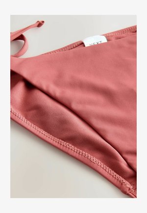 Rosa bikiniöverdel med en slät, strukturerad finish, som har en enkel design och justerbara knytband på ena sidan.