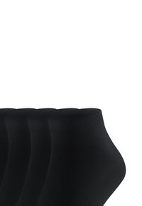 Schwarze Crew-Socken mit geripptem Muster, ausgestattet mit einem glatten oberen Bund und einer figurschmeichelnden Form, in einer versetzten Anordnung präsentiert.