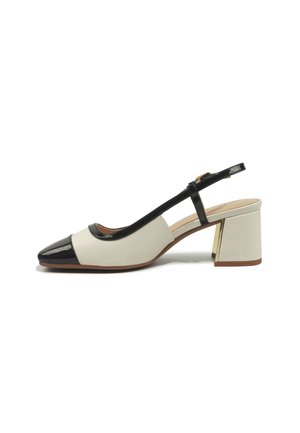 Dvoubarevná béžovo-černá slingback bota s špičatou špičkou, nízkým širokým podpatkem a detaily zlaté přezky na bílém pozadí.