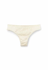 Cream-colored thong made of smooth fabric, featuring floral lace detailing at the front and a simple elastic waistband.