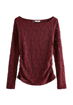Top lungo bordeaux a maniche con pizzo e motivo floreale, caratterizzato da un ampio scollo e dettagli arricciati sui lati per una texture aggiuntiva.