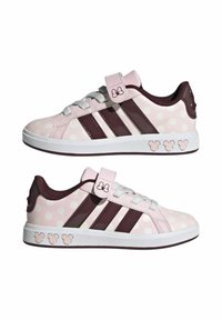 Baskets roses à pois avec des accents bordeaux et trois rayures, fermeture velcro et semelle blanche. Comprend des détails de Mickey Mouse sur le côté.