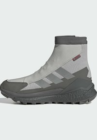 High-top, gray athletic shoes with a textured fabric upper, rubber toe cap, and pronounced tread on the sole. Features three stripes design.