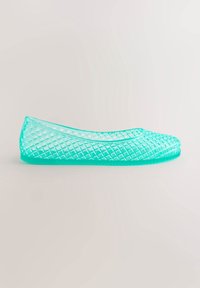 Chaussure plate turquoise translucide avec un motif en mesh à losanges et un bout arrondi, vue de profil sur un fond clair.
