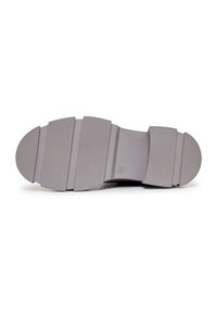Suela de zapato de goma gris con un patrón texturizado, que presenta secciones amplias segmentadas para un mejor agarre y bordes redondeados. Diseño plano y uniforme.