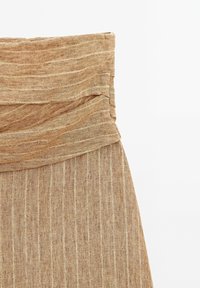 Jupe en lin marron clair avec des rayures verticales et une large ceinture pliée.