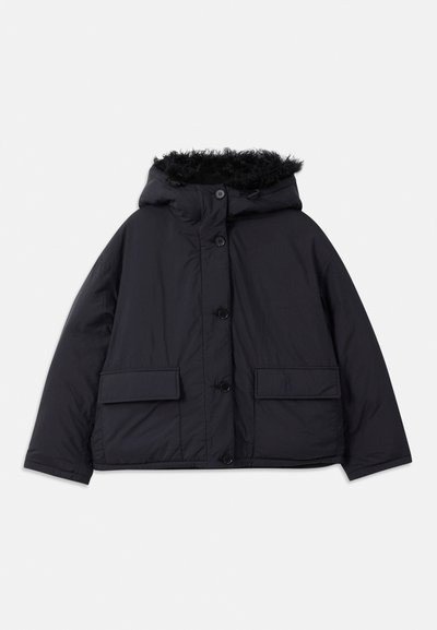 Giubbotto puffer nero con cappuccio, rifinitura in pelliccia sintetica, bottoni a scatto e tasche laterali. Presenta una vestibilità ampia e un materiale morbido e leggero.