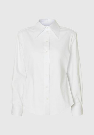 Camicia bianca con colletto grande a punta, maniche lunghe e orlo curvo. Realizzata in tessuto liscio, dotata di chiusura frontale con bottoni.