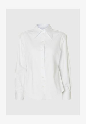 White button-up shirt with a large pointed collar, long sleeves, and a curved hem. Made of smooth fabric, featuring front button closure.