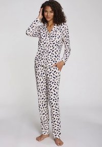 Pitkähihainen pyjama-setti, jossa napillinen yläosa ja joustavyötärölliset housut. Setissä on kerma-taustainen tummansininen abstrakti lehtikuvio.