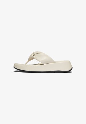 Beige sleehak flip-flop sandaal met gewatteerde gedraaide band en zwarte zool, zijaanzicht op een witte achtergrond.