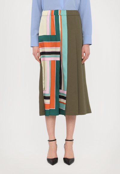 Jupe mi-longue avec une taille élastique. Présente un patchwork coloré et géométrique en vert, orange, bleu sarcelle et crème d'un côté.
