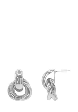 Boucles d’oreilles en métal ton argent avec design de boucles entrelacées et fermeture par tige, vues de face et de côté sur fond blanc.