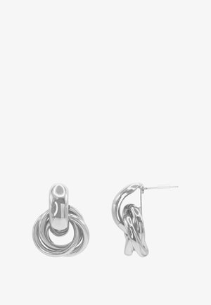 Boucles d’oreilles en métal ton argent avec design de boucles entrelacées et fermeture par tige, vues de face et de côté sur fond blanc.