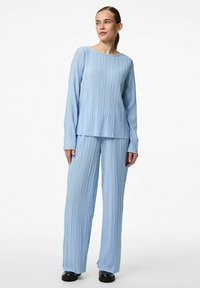 Ljusblå, veckad lounge-set som består av en långärmad topp och vida byxor. Slät textur med en avslappnad silhuett och rund halsringning.