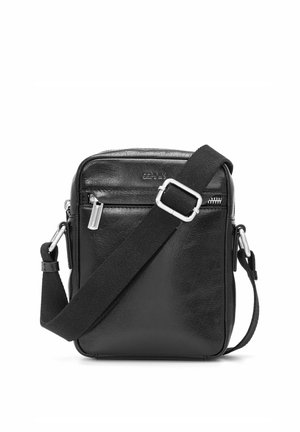 Czarna skórzana torba na ramię z regulowanym, szerokim paskiem materiałowym i przednią kieszenią na suwak, kompaktowy, prostokątny kształt.