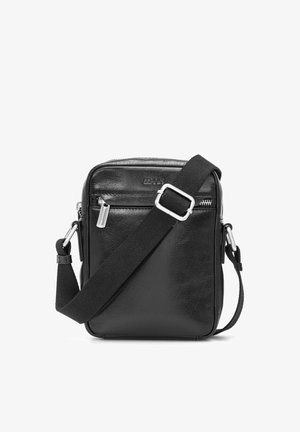 Czarna skórzana torba na ramię z regulowanym, szerokim paskiem materiałowym i przednią kieszenią na suwak, kompaktowy, prostokątny kształt.