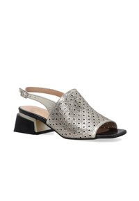 Metallisch silberner Slingback-Schuh mit offenen Zehen, geometrischem Muster und einem niedrigen Blockabsatz in Schwarz und silbernen Akzenten.