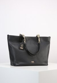 Svart läder tote-väska med texturerad yta, guldfärgade detaljer, dubbla handtag och logotags. Rymlig och rektangulär design.