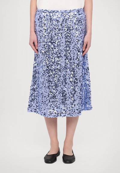 Paillettenrock in Hellblau mit einer glänzenden, strukturierten Oberfläche. Midi-Länge mit ausgestellt Silhouette und elastischem Taillenbund. Schwarze Ballerinas sichtbar.