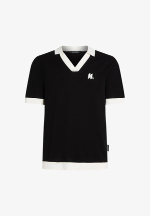 Camiseta de punto negra con cuello en V, collar blanco y acentos en los puños. Presenta un pequeño logotipo blanco en el pecho. Textura suave.