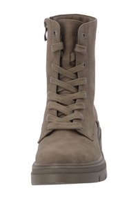 Bottine en daim marron avec bout rond, système de laçage sur le devant et fermeture éclair latérale. Elle présente une semelle texturée et une teinte neutre.