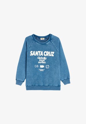 Sudadera azul con puños y cuello acanalados. En el frontal presenta un texto en blanco: "SANTA CRUZ Globally Local Surfers" y varios gráficos.