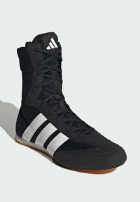 Czarny sportowy but wykonany z siateczki i materiału syntetycznego. Posiada wysoką cholewkę, czarne sznurowadła oraz trzy białe paski po boku. Gumowa podeszwa.