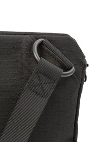 Schwarze, getäfelte Tasche, die einen Metallring und einen Riemenaufhängung zeigt und die robuste Konstruktion sowie die praktischen Designelemente betont.