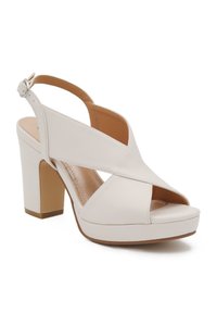 Sandalo bianco in pelle con tacco alto, punta aperta, design con cinturini incrociati, cinturino alla caviglia regolabile e tacco largo.