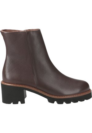 Brown leather ankle boot with a textured finish, featuring a chunky black heel and contrasting brown sole stitching, displaying a sleek design.
