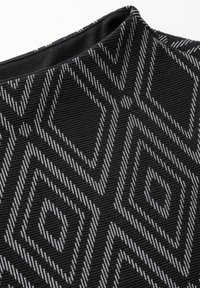 Svart tyg med ett texturerat, geometriskt mönster av diamanter och linjer i kontrasterande vitt. Slät yta med en lätt glans.