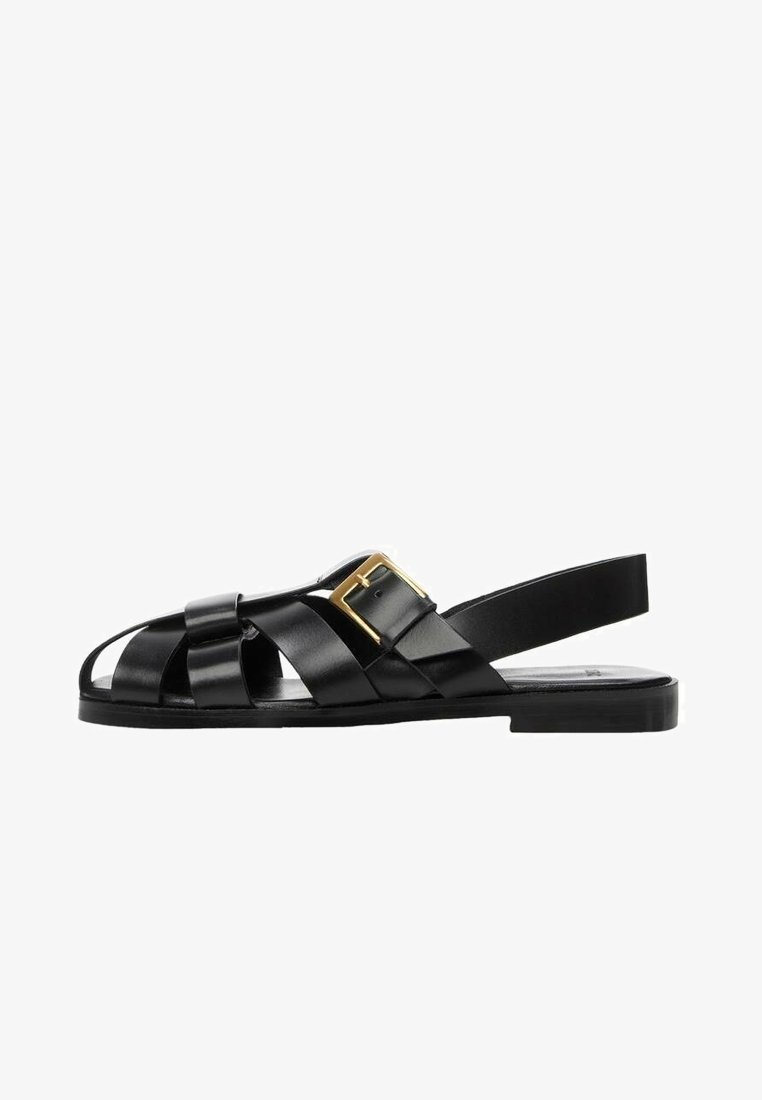 Sandales noires en cuir avec un design ouvert, dotées de brides croisées, d'une boucle élégante et d'une semelle plate pour le confort.