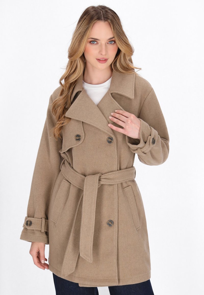 Beige wool trench coat with a belted waist, double-breasted front, and large lapels. Features two side pockets and button accents on sleeves.