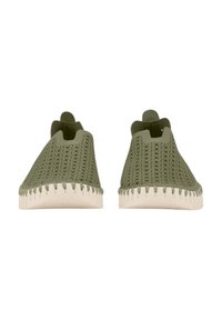 Zapatos verdes de lona tipo slip-on con suelas color crema, que presentan un upper texturizado y sin cordones, diseñados para un uso fácil.