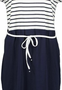 Abito a strisce con parte superiore bianca a righe navy, gonna blu navy e una cintura bianca con stringa che si annoda in vita. Tessuto dalla consistenza liscia.