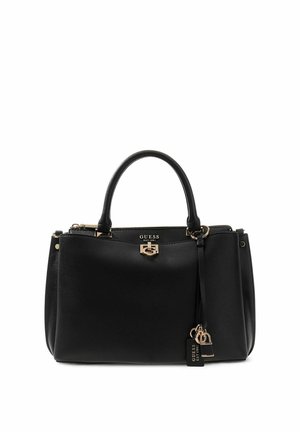 Sac à main noir Guess avec deux poignées, fermoir doré et breloque de marque attachée sur fond blanc.