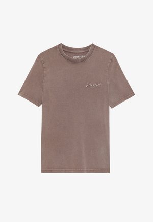 T-shirt en coton marron à manches courtes, col rond et logo brodé sur la poitrine. Il présente un tissu doux et légèrement texturé.
